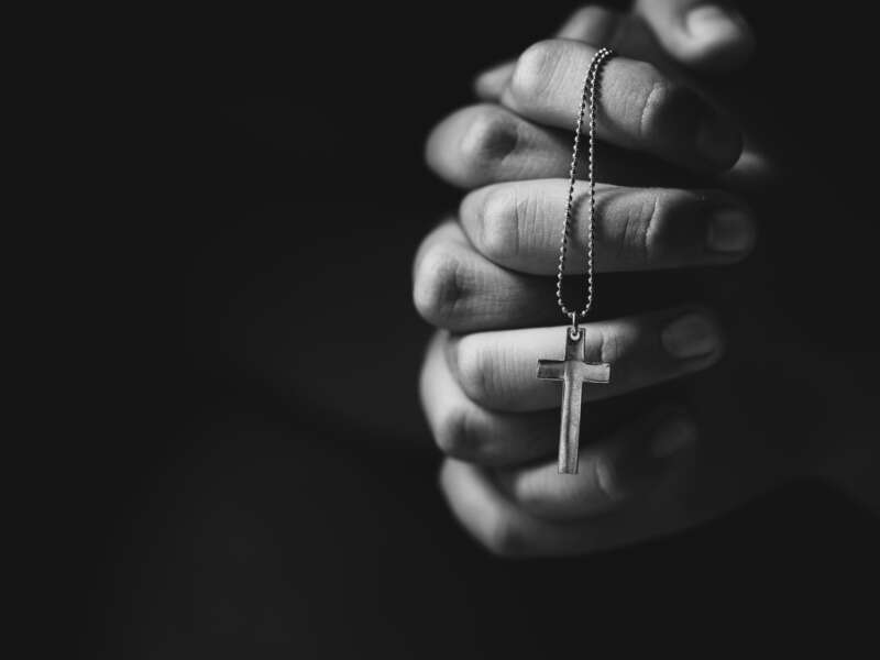 Hands holding cross while praying